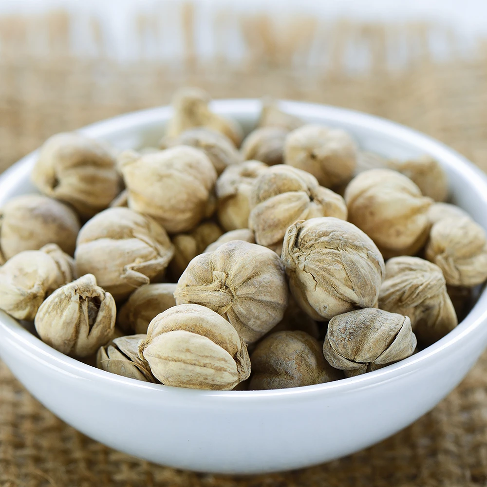 A white bowl filled with dried cardamom pods, highlighting agricultural and commodity supply.